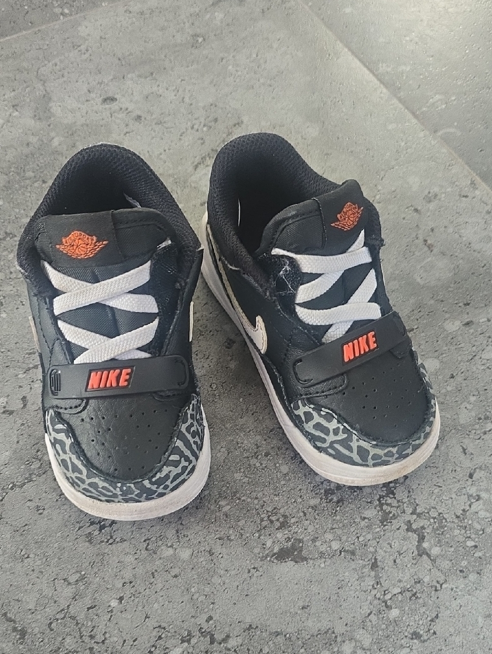 Nike Kids Black Sneakers with White Laces and Orange Logos